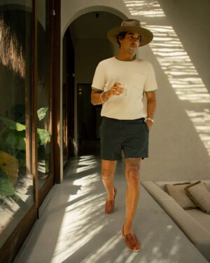 a man wearing a Dandy Del Mar Cannes Waffle Knit Tee - Vintage Ivory and shorts.