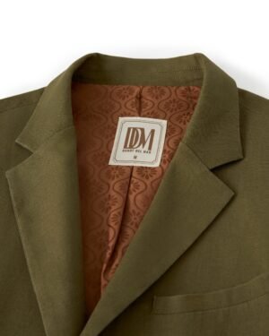 Close-up of an olive-green linen blazer with a brown jacquard-patterned inner lining. The label reads 