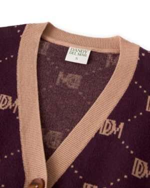 Close-up of The Canela Cardigan - Amethyst, featuring a rich dark purple cotton design with tan trim, highlighting the 