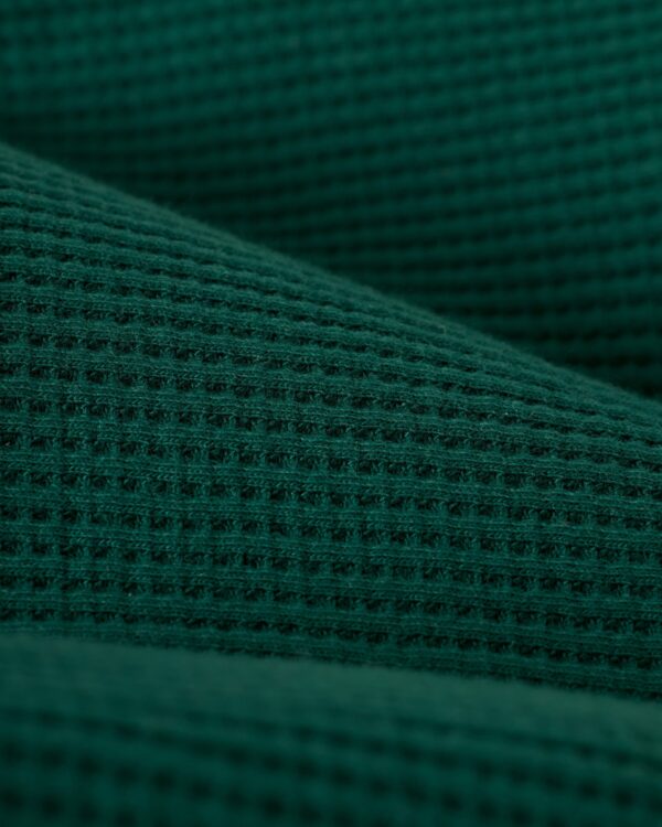 Close-up of The Cannes Waffle Knit Robe - Albero by Dandy Del Mar, highlighting its green waffle-textured pattern and texture.