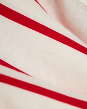 A close up of The Crete Linen Shirt - Pico by Dandy Del Mar, a red and white striped fabric.