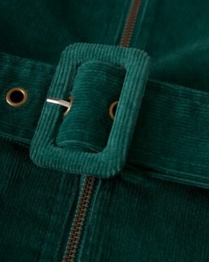 Close-up of The Kitts Corduroy Dress - Albero by Dandy Del Mar, featuring a green corduroy waist belt with a rectangular buckle that perfectly complements the slim fit of the garment.