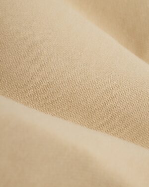 Close-up of ginger fabric with a slightly ribbed texture and subtle color variations, reminiscent of The Marseille French Terry Short - Ginger by Dandy Del Mar.