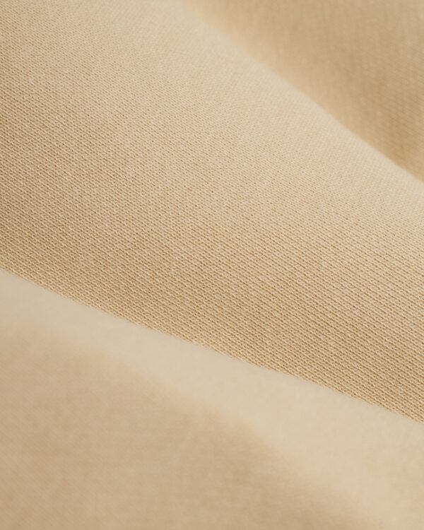 Close-up of ginger fabric with a slightly ribbed texture and subtle color variations, reminiscent of The Marseille French Terry Short - Ginger by Dandy Del Mar.
