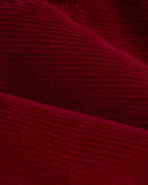 Close-up view of Italian corduroy fabric, showcased in the Dandy Del Mar Corsica Corduroy Jacket - Sangria, highlighting its rich, textured, ribbed surface.