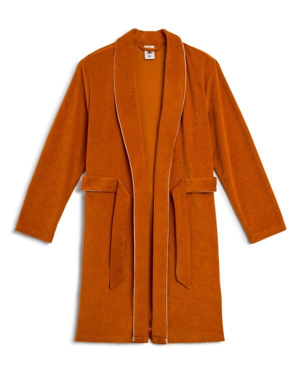 The Tropez Robe by Dandy Del Mar in Burnt Sienna is ultra-soft Terry Cloth with white piping, featuring a shawl collar, long sleeves, and a waist belt. Its above-the-knee fit adds a modern touch to your lounging experience.