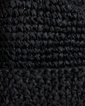 Close-up view of a textured black fabric with a detailed raffia-effect crochet pattern on The Amabile Raffia Hat in Onyx by Dandy Del Mar.