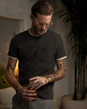 A tattooed man in glasses and a dark, breathable 