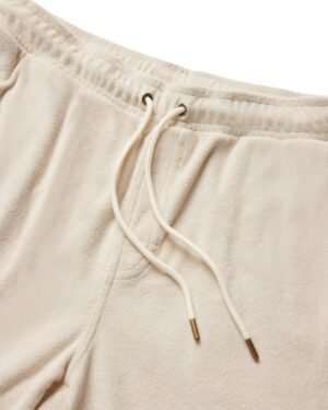 Close-up of The Gaucho Shorts in Alabaster from Dandy Del Mar, presenting an Equatorial Cowboy vibe with a cream-colored terry cloth finish and a drawstring waistband with metal-tipped ends.